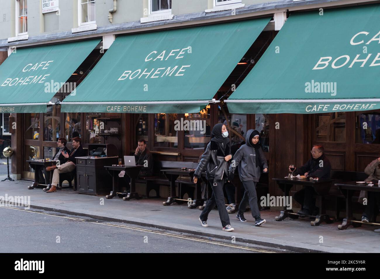 La gente si vede seduti fuori da un pub a Soho prima dell'introduzione di restrizioni più severe per il coronavirus nel periodo che precede Natale, il 15 dicembre 2020 a Londra, Inghilterra. Da domani, la Greater London, così come alcune parti dell'Essex e dell'Hertfordshire, passerà alle restrizioni sui coronavirus di livello 3 con conseguente chiusura di pub, bar, ristoranti, hotel e locali di intrattenimento al coperto come teatri e cinema, in quanto i tassi di infezione sono ben al di sopra della media nazionale e continuano ad aumentare. (Foto di Wiktor Szymanowicz/NurPhoto) Foto Stock