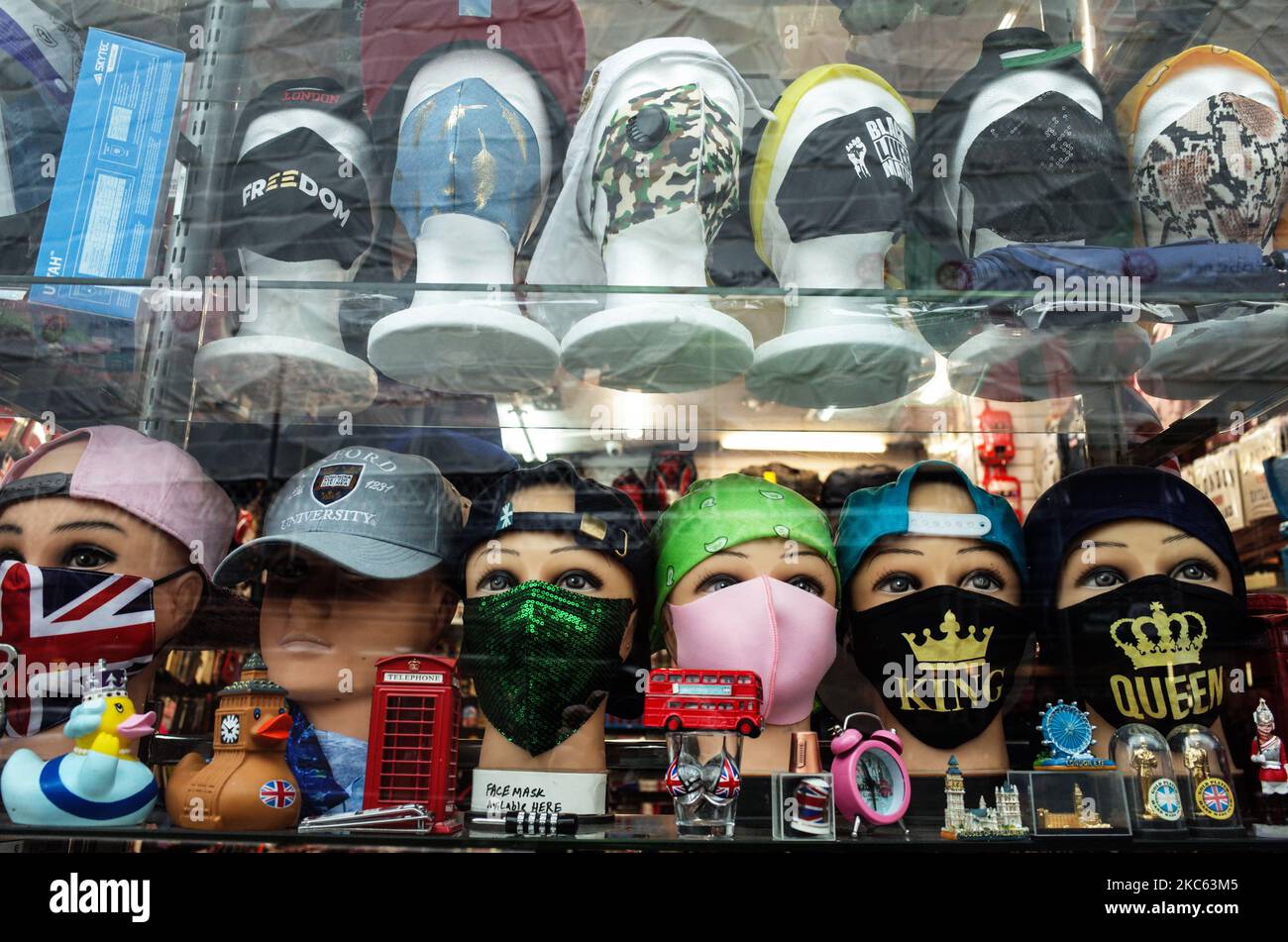 Le teste dei manichini che indossano maschere facciali siedono in mezzo a memorabilia a tema londinese nella finestra di un negozio di souvenir turistico a Kensington High Street a Londra, Inghilterra, il 18 dicembre 2020. Le restrizioni di livello 3 sono iniziate a Londra il mercoledì tra le preoccupazioni delle autorità per l'aumento dei numeri covid-19 test positivi in città. I negozi possono rimanere aperti nelle aree di livello 3, ma le aziende del settore alberghiero sono limitate solo ai servizi di asporto e consegna e i luoghi di intrattenimento, inclusi teatri e cinema, devono essere chiusi. (Foto di David Cliff/NurPhoto) Foto Stock