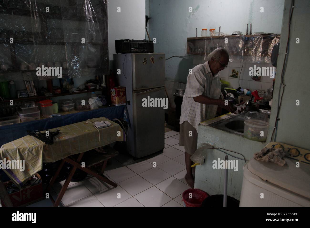Harry dalle (73), un sopravvissuto di Covid-19, fa le sue attività a casa durante il secondo giorno di Natale a Bekasi, provincia di Giava Occidentale, il 26 dicembre 2020. Come sopravvissuto, Harry dalle sentì davvero come il Covid-19 che lo attaccò lo rese incapace di prendersi cura del fratello minore, Marthen dalle, che stava combattendo il cancro spinale. Il periodo di isolamento di 15 giorni in ospedale ha lasciato il fratello minore, Marthen, che è l'unica famiglia con cui vive, trascurato fino a quando la sua condizione non ha continuato a deteriorarsi. E quando Harry fu provato negativo per Covid-19, e tornò a casa, trovò le condizioni del fratello minore Foto Stock