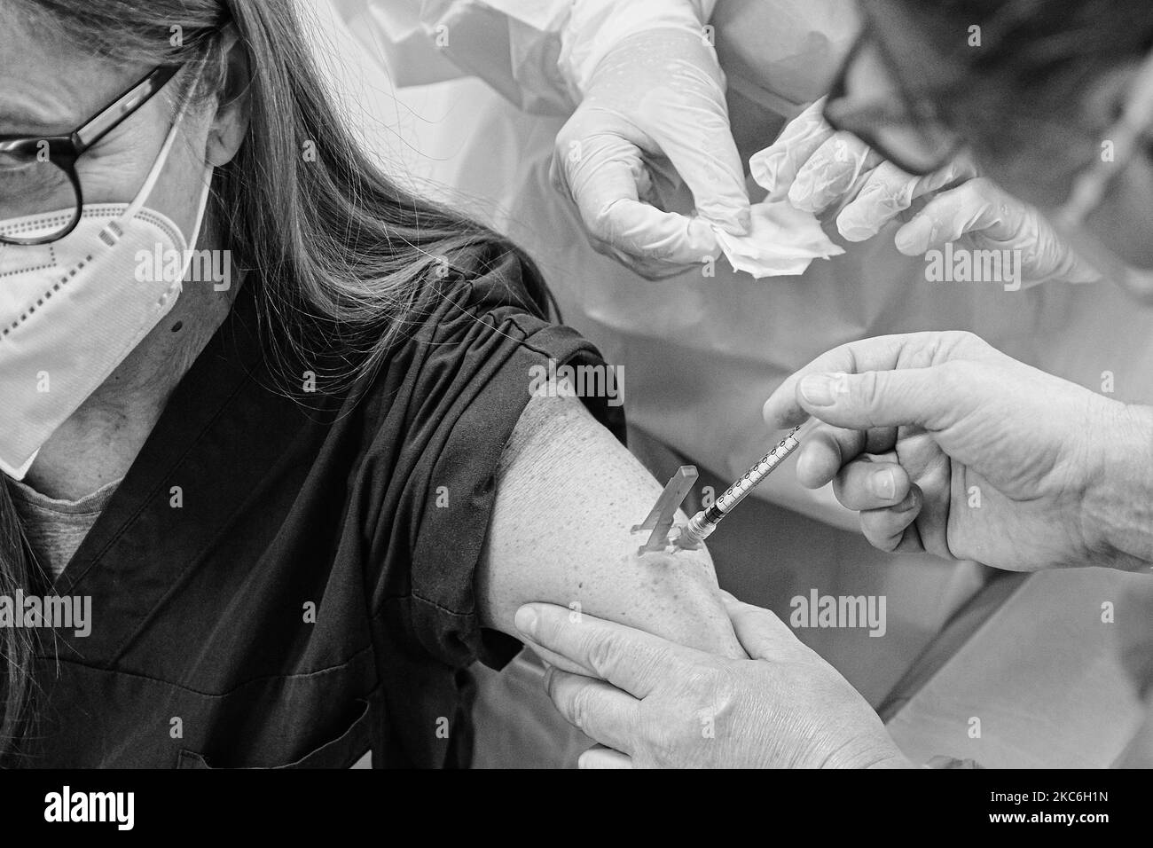 (NOTA DELL'EDITORE: L'immagine è stata convertita in bianco e nero) il vaccino contro il Covid19 sviluppato da Pfizer-Biontech è ora distribuito in tutti gli ospedali italiani, e in questo caso presso l'ospedale Schiavonia. Il personale sanitario, schierato in prima linea nella guerra contro la diffusione del virus, sarà il primo a ricevere il vaccino. Nella foto un medico dell'ospedale Schiavonia mentre si vaccina. Schiavonia, Padova, Italia, 27 dicembre 2020. (Foto di Roberto Silvino/NurPhoto) Foto Stock