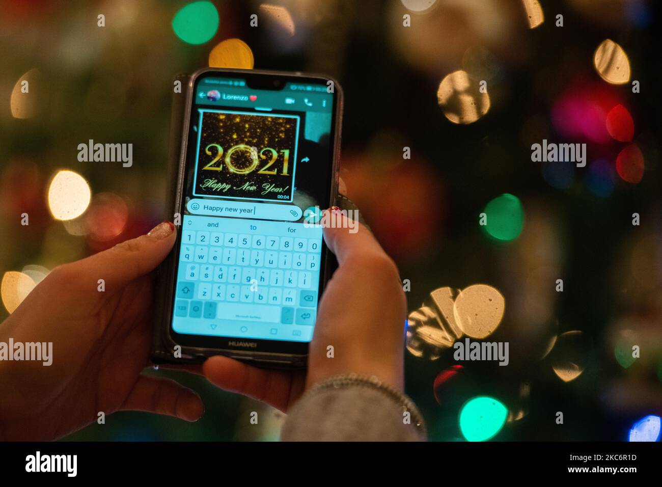 Una ragazza italiana festeggia a casa il 2021° anno e invia un messaggio di auguri Whatsapp a l'Aquila il 1 gennaio 2021. (Foto di Lorenzo di Cola/NurPhoto) Foto Stock
