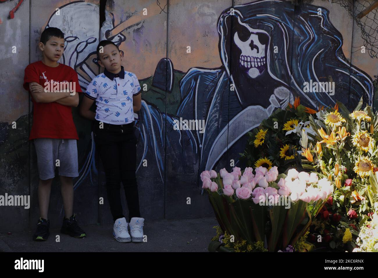 Due bambini al di fuori del Tempio di Santa Muerte, noto anche come la Niña Blanca, situato a Tepito, Città del Messico. Le autorità di capitale hanno decretato alcune settimane fa il ritorno al semaforo rosso epidemiologico a causa dell'aumento dei casi di coronavirus e di occupazione ospedaliera quasi alla massima capacità, per cui la sospensione di tutte le attività non essenziali continuerà fino al 10 gennaio 2021. (Foto di Gerardo Vieyra/NurPhoto) Foto Stock