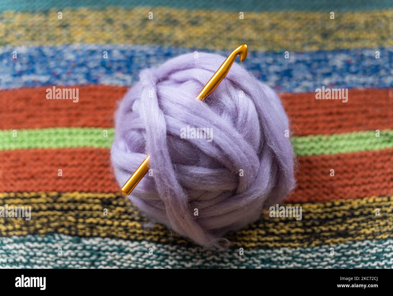 Palla viola chiaro di lana dell'isola olandese di Texel, filo spesso con ago a crochet, fuoco selettivo Foto Stock