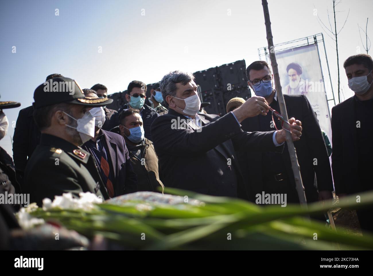 Il sindaco di Teheran Pirouz Hanachi (C) lega una targa simbolica con il nome di una vittima del volo internazionale ucraino 752 su una sunpling durante una cerimonia per celebrare l'anniversario della morte dell'ex corpo della Guardia rivoluzionaria Islamica (IRGC) Quds Force, Qasem Soleimani e 176 vittime del volo 752, nel cimitero di Behesht-e zahra a sud di Teheran il 7 gennaio 2021. Il volo ucraino 752 era un volo internazionale di linea da Teheran a Kyiv il 8th gennaio 2020 che ha abbattito poco dopo il decollo dall'aeroporto internazionale Imam Khomeini di Teheran da parte della rivoluzione islamica Foto Stock