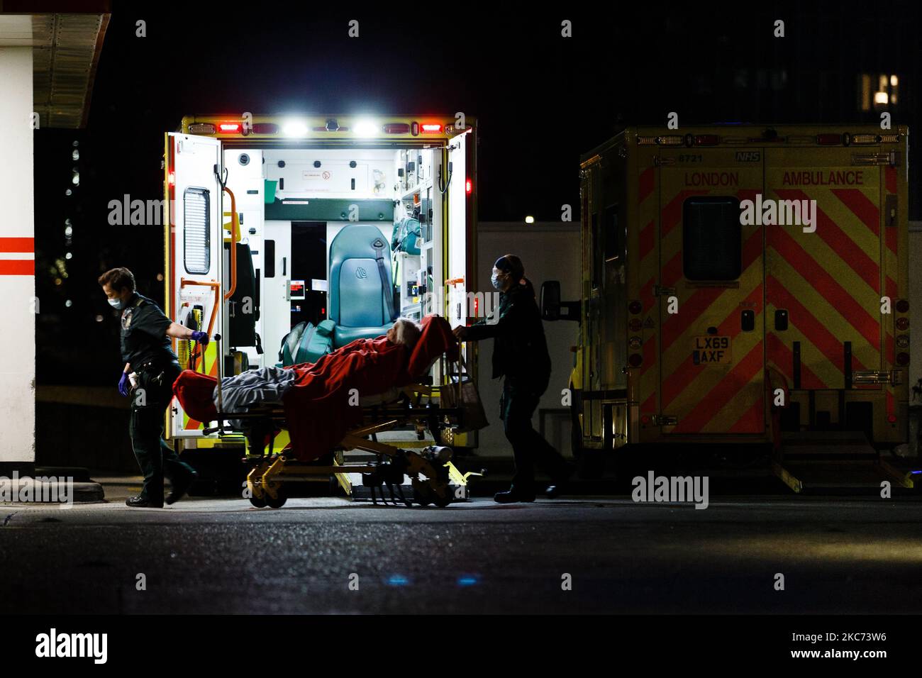 Il personale dell'ambulanza che indossa maschere facciali ruota un paziente anziano nel St Thomas' Hospital di Londra, Inghilterra, il 7 gennaio 2021. All'inizio di questa settimana l'Inghilterra ha iniziato un terzo blocco nazionale del coronavirus, con la preoccupazione delle autorità di far sì che il Servizio sanitario Nazionale (NHS) possa presto essere sopraffatto dai malati di covid-19. Nel frattempo, il primo ministro britannico Boris Johnson ha annunciato oggi che 1,5m persone in tutto il Regno Unito hanno ricevuto almeno una prima dose di vaccino Covid-19, con piani per centinaia di migliaia di vaccinazioni da somministrare ogni giorno a partire dalla metà di questo mese, con l’assistenza militare Foto Stock