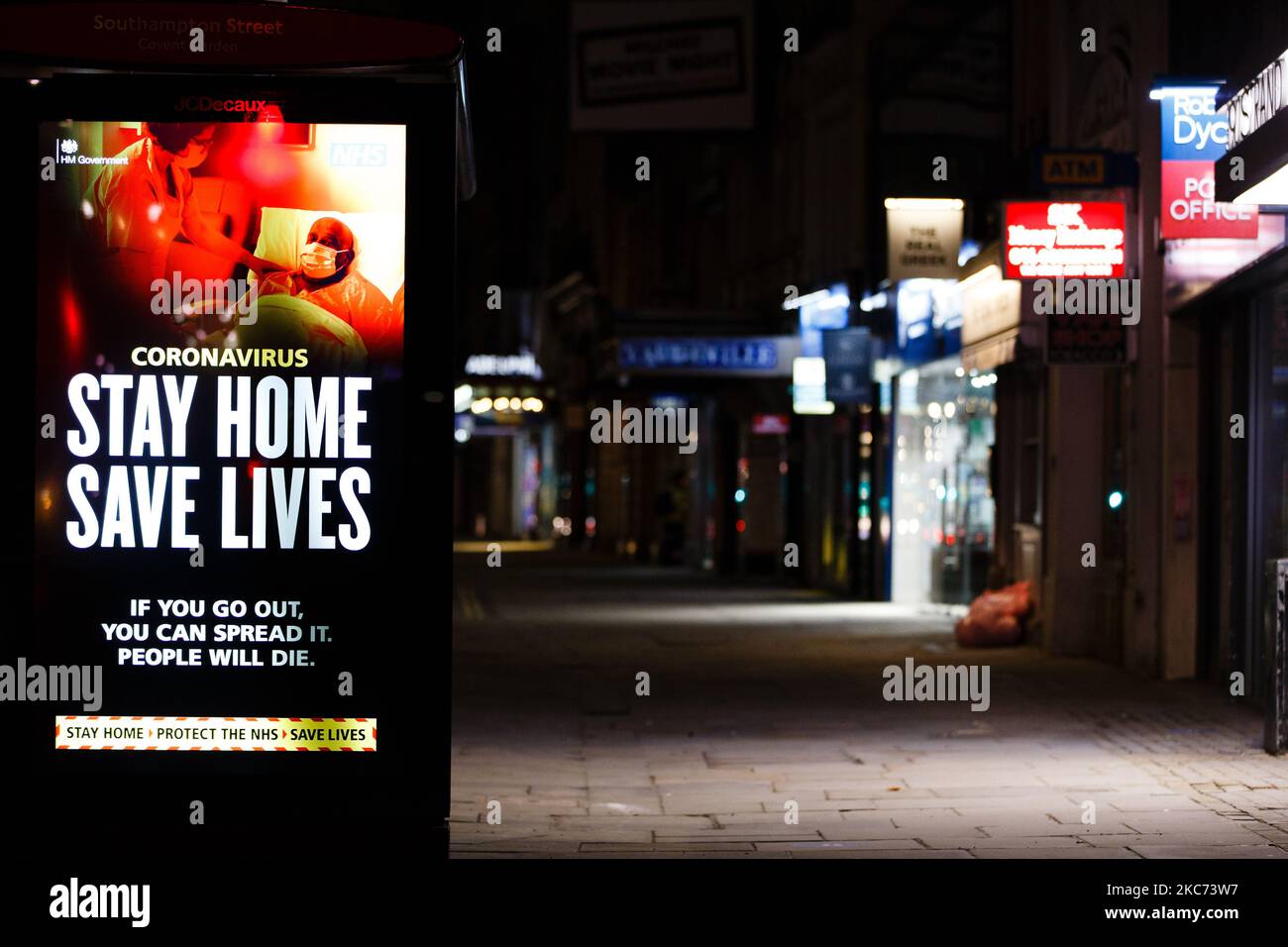 I messaggi del governo che dicono alle persone di rimanere a casa illuminano lo schermo della pubblicità digitale di una fermata dell'autobus su uno Strand vicino deserto a Londra, Inghilterra, il 7 gennaio 2021. All'inizio di questa settimana l'Inghilterra ha iniziato un terzo blocco nazionale del coronavirus, con la preoccupazione delle autorità di far sì che il Servizio sanitario Nazionale (NHS) possa presto essere sopraffatto dai malati di covid-19. Nel frattempo, il primo ministro britannico Boris Johnson ha annunciato oggi che 1,5m persone in tutto il Regno Unito hanno ricevuto almeno una prima dose di vaccino covid-19, con piani per centinaia di migliaia di vaccinazioni da somministrare ogni giorno Foto Stock