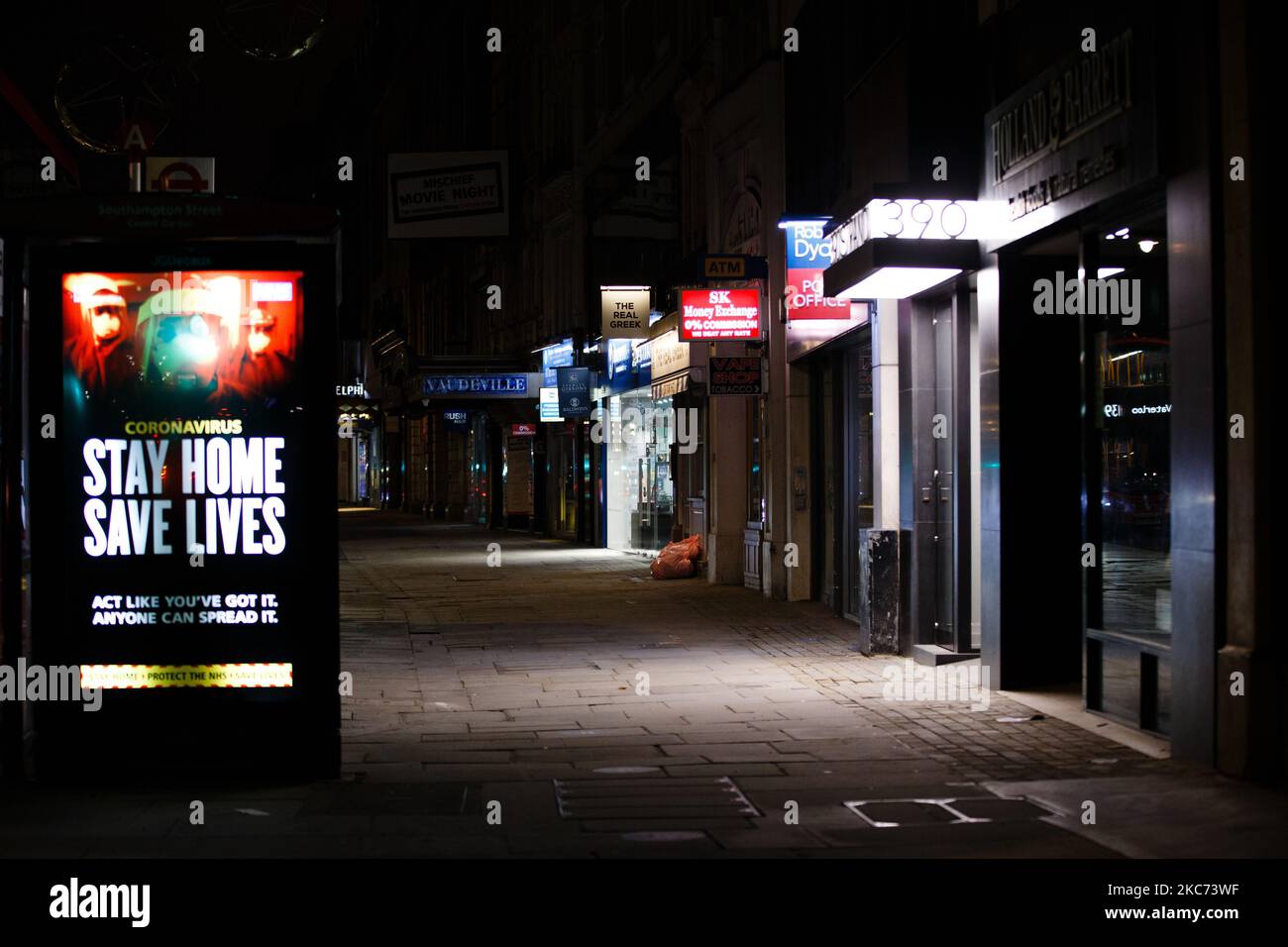 I messaggi del governo che dicono alle persone di rimanere a casa illuminano lo schermo della pubblicità digitale di una fermata dell'autobus su uno Strand vicino deserto a Londra, Inghilterra, il 7 gennaio 2021. All'inizio di questa settimana l'Inghilterra ha iniziato un terzo blocco nazionale del coronavirus, con la preoccupazione delle autorità di far sì che il Servizio sanitario Nazionale (NHS) possa presto essere sopraffatto dai malati di covid-19. Nel frattempo, il primo ministro britannico Boris Johnson ha annunciato oggi che 1,5m persone in tutto il Regno Unito hanno ricevuto almeno una prima dose di vaccino covid-19, con piani per centinaia di migliaia di vaccinazioni da somministrare ogni giorno Foto Stock