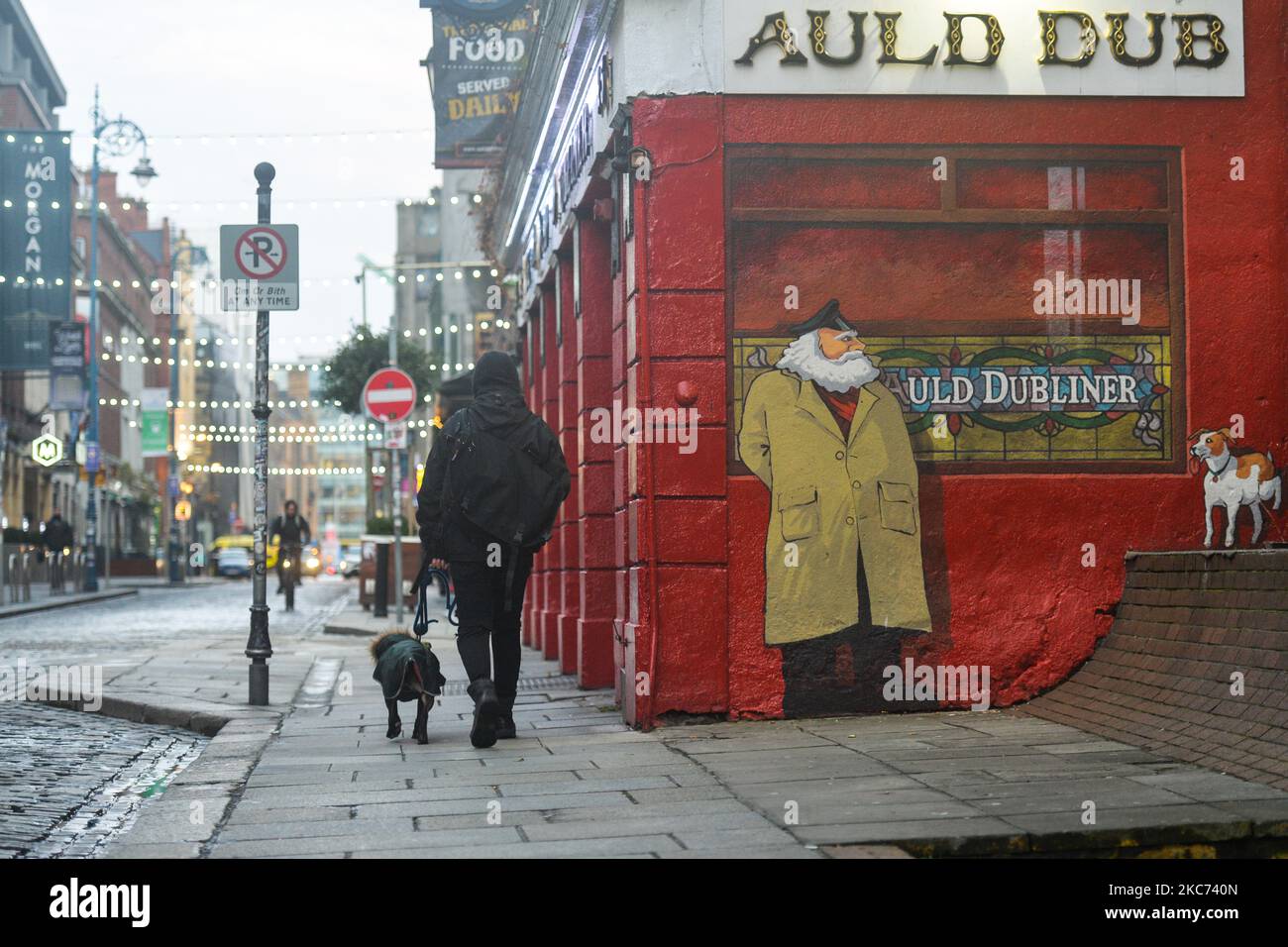 Un uomo con un cane cammina in un pub chiuso al Temple Bar di Dublino. Giovedì 7 gennaio 2021 a Dublino, Irlanda. (Foto di Artur Widak/NurPhoto) Foto Stock