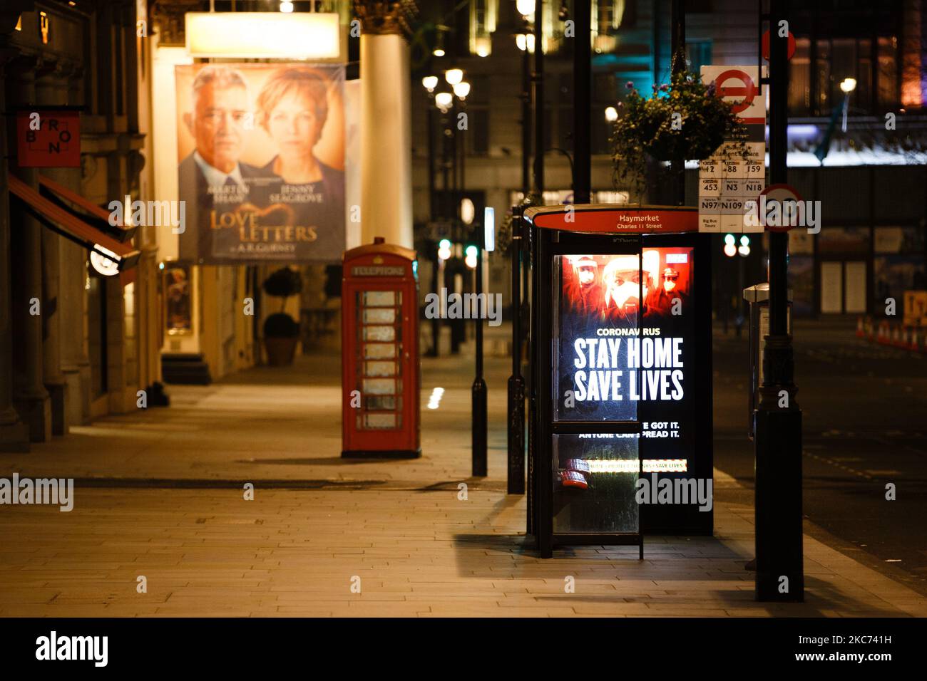 I messaggi del governo che dicono alle persone di rimanere a casa illuminano lo schermo della pubblicità digitale di una fermata dell'autobus su un Haymarket quasi deserto a Londra, Inghilterra, il 7 gennaio 2021. All'inizio di questa settimana l'Inghilterra ha iniziato un terzo blocco nazionale del coronavirus, con la preoccupazione delle autorità di far sì che il Servizio sanitario Nazionale (NHS) possa presto essere sopraffatto dai malati di covid-19. Nel frattempo, il primo ministro britannico Boris Johnson ha annunciato oggi che 1,5m persone in tutto il Regno Unito hanno ricevuto almeno una prima dose di vaccino covid-19, con piani per centinaia di migliaia di vaccinazioni da somministrare ogni giorno f Foto Stock