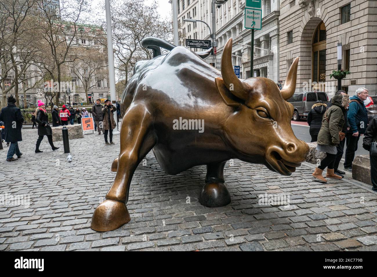 La scultura in bronzo di Charging Bull, conosciuta anche come Bull di Wall Street o Bowling Green Bull a New York City, con i turisti intorno a scattare foto di esso in quanto è un punto di riferimento, una destinazione turistica, Un'attrazione popolare e simbolo per Wall Street e il quartiere finanziario, con aggressivo ottimismo finanziario e prosperità, ricchezza e fortuna, situato a Broadway presso il quartiere finanziario di Manhattan. Fu creato da Arturo di Modica nel 1989. New York, USA il 2019 novembre (Foto di Nicolas Economou/NurPhoto) Foto Stock