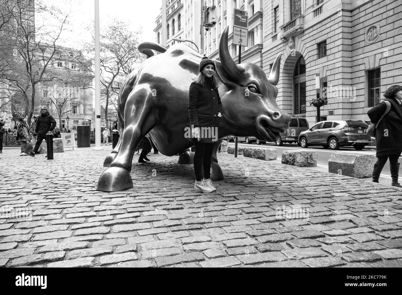 Foto in bianco e nero della scultura in bronzo di Charging Bull, conosciuta anche come Wall Street Bull o Bowling Green Bull a New York City, con i turisti che ne scattano foto in quanto è un punto di riferimento, una destinazione turistica, Un'attrazione popolare e simbolo per Wall Street e il quartiere finanziario, con aggressivo ottimismo finanziario e prosperità, ricchezza e fortuna, situato a Broadway presso il quartiere finanziario di Manhattan. Fu creato da Arturo di Modica nel 1989. New York, USA il 2019 novembre (Foto di Nicolas Economou/NurPhoto) Foto Stock