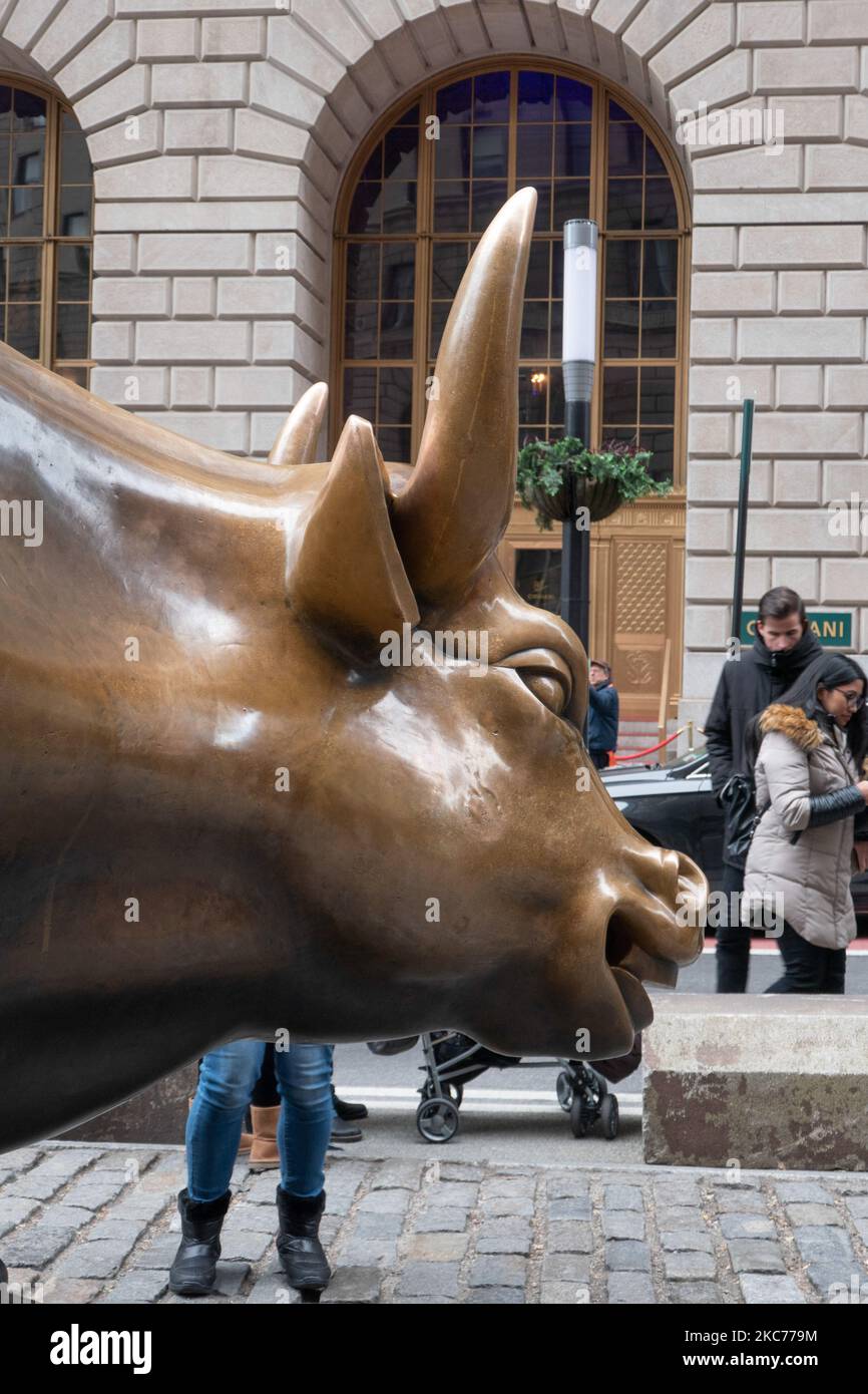 La scultura in bronzo di Charging Bull, conosciuta anche come Bull di Wall Street o Bowling Green Bull a New York City, con i turisti intorno a scattare foto di esso in quanto è un punto di riferimento, una destinazione turistica, Un'attrazione popolare e simbolo per Wall Street e il quartiere finanziario, con aggressivo ottimismo finanziario e prosperità, ricchezza e fortuna, situato a Broadway presso il quartiere finanziario di Manhattan. Fu creato da Arturo di Modica nel 1989. New York, USA il 2019 novembre (Foto di Nicolas Economou/NurPhoto) Foto Stock