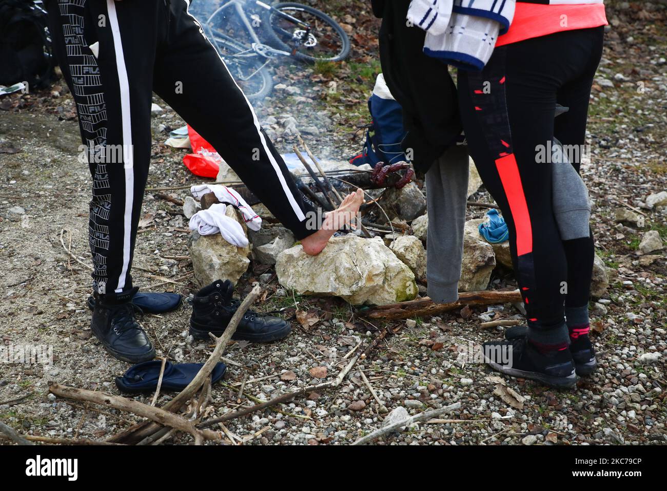 Il nuotatore invernale scalda il piede da un incendio dopo aver nuotato nelle fredde acque del lago Zakrzowek, un'ex cava di calcare situata vicino al centro della città di Cracovia, Polonia, il 10th gennaio 2021. Le restrizioni introdotte in Polonia a causa della pandemia del coronavirus hanno portato alla chiusura continua delle piscine pubbliche, delle palestre e di altri centri sportivi. I fan delle attività fisiche che vogliono rafforzare il loro corpo e il sistema immunitario sono sempre più disposti a fare un bagno d'inverno in riserve naturali di acqua fredda. Il nuoto invernale è diventato estremamente popolare tra le persone polacche di tutte le età. (Foto di B Foto Stock