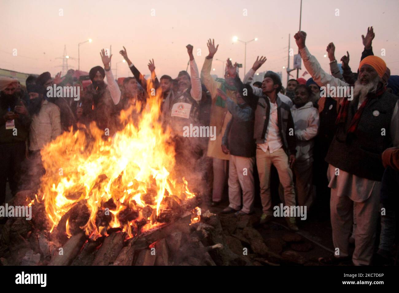 Gli agricoltori che protestano celebrano il festival di Lohri intorno a un falò, mentre bloccano una grande autostrada in protesta contro le nuove leggi agricole al confine di stato Delhi-Utttar Pradesh vicino Ghazipur alla periferia di Nuova Delhi, India il 13 gennaio 2021. Decine di migliaia di agricoltori protestano per 49 giorni presso i punti di ingresso principali della capitale nazionale. (Foto di Mayank Makhija/NurPhoto) Foto Stock