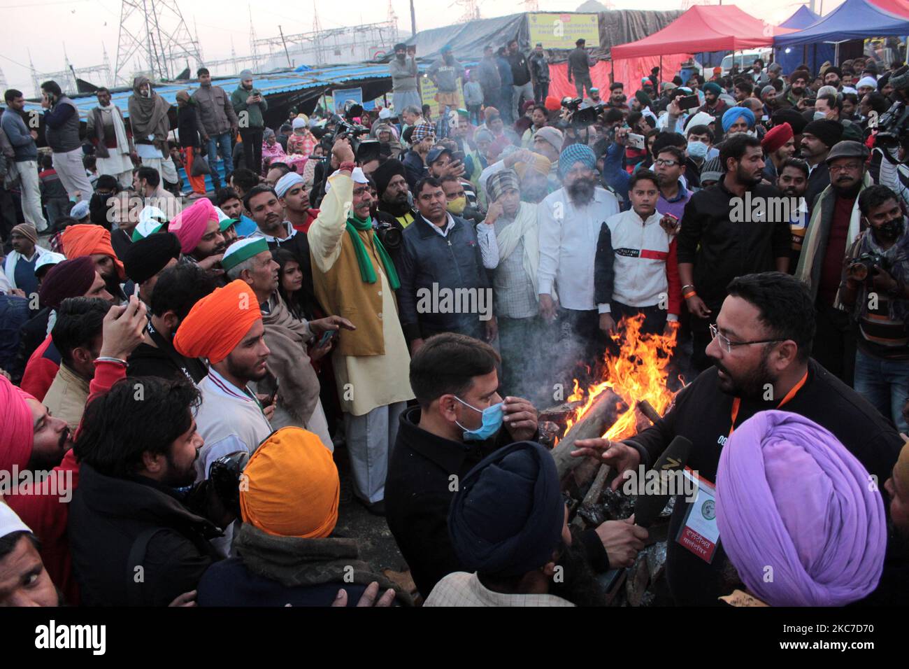 Gli agricoltori che protestano celebrano il festival di Lohri intorno a un falò, mentre bloccano una grande autostrada in protesta contro le nuove leggi agricole al confine di stato Delhi-Utttar Pradesh vicino Ghazipur alla periferia di Nuova Delhi, India il 13 gennaio 2021. Decine di migliaia di agricoltori protestano per 49 giorni presso i punti di ingresso principali della capitale nazionale. (Foto di Mayank Makhija/NurPhoto) Foto Stock
