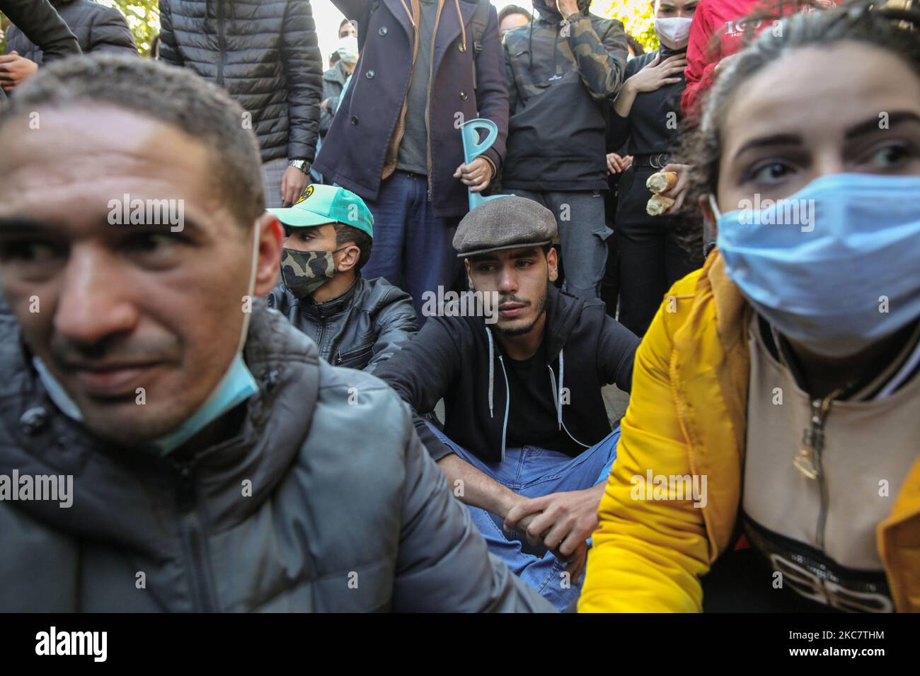 I giovani manifestanti si siedono sul campo durante una manifestazione anti-governativa svoltasi in Avenue Habib Bourguiba, nella capitale Tunisi, il 19 gennaio 2021, per protestare contro il governo del primo ministro Hichem Mechichi, E a sostegno dei movimenti di protesta che hanno colpito la Tunisia in diverse città durante la notte degli ultimi giorni. I manifestanti si scontrarono con le forze di sicurezza che spararono gas lacrimogeni e usarono spray al pepe nel tentativo di disperderli. Hanno anche chiesto il rilascio di giovani arrestati dalla polizia durante le ultime proteste, e denunciato l'alto costo della vita e l'incre Foto Stock