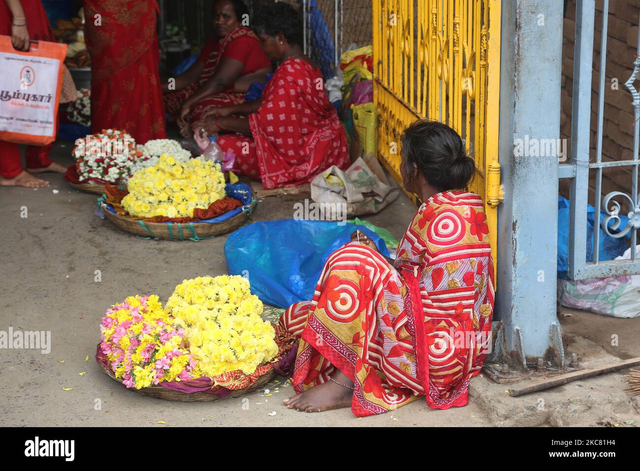 Le donne vendono fiori al tempio di Amman di Melmaruvathur, situato a Melmaruvathur, Tamil Nadu, India. Arulmigu Adhiparasakthi Siddhar Peetam è il luogo dove 21 Siddhars (santi) uomini e donne di diverse religioni, hanno avuto loro Jeeva-Samadhis (cioè, dove i Siddhars hanno lasciato le loro forme umane dietro, mentre sono ancora vivi come spiriti santi). Qui in Melmaruvathur Adiparashakti Siddhar Peetam, la madre divina Adhi para sakthi trasmigrate in Arulthiru Bangaru Adigalar promuovendo così la spiritualità e la devozione. Arul Thiru Bangaru Adigalar è chiamato dai suoi devoti come AMMA (mezzi Foto Stock