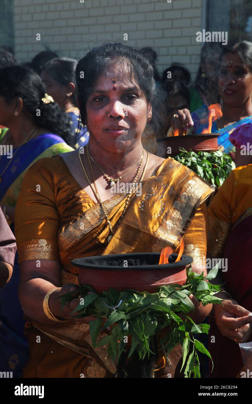 La donna indù Tamil porta una pentola di argilla con la canfora fiammeggiante mentre prende parte ad una processione religiosa che accompagna il carro che porta l'idolo di Lord Vinayagar durante il Vinayagar Ther Thiruvizha Festival in un tempio indù Tamil in Ontario, Canada, il 23 luglio 2016. Questo festival fa parte del festival di 15 giorni che onora Lord Ganesh che culmina con questa stravagante processione dei carri. (Foto di Creative Touch Imaging Ltd./NurPhoto) Foto Stock