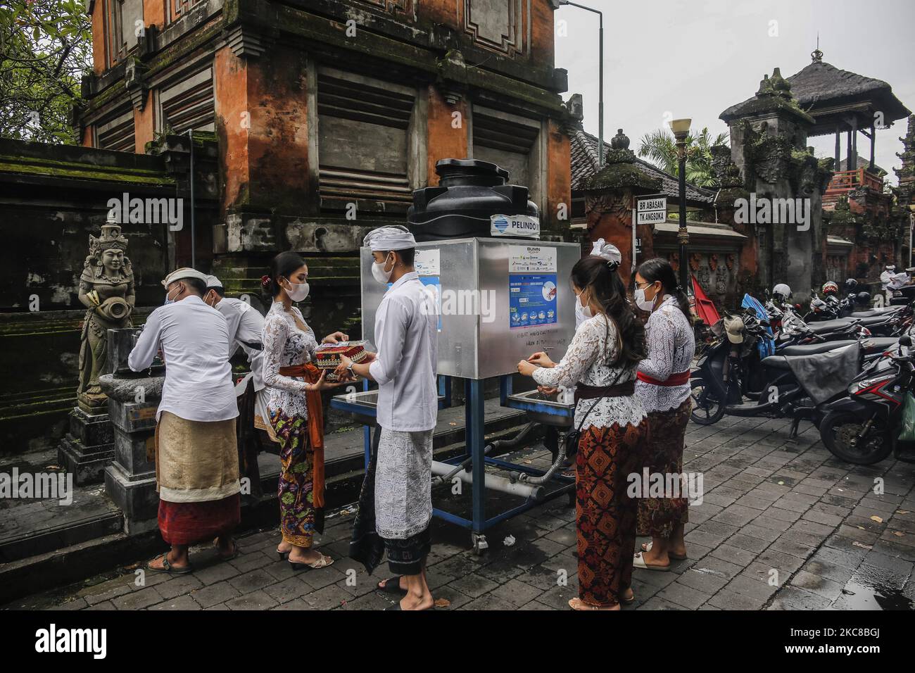 I devoti indù balinesi si lavano le mani prima di entrare nel tempio durante la cerimonia di Saraswati, la Dea della conoscenza, in mezzo alla pandemia COVID-19 nel tempio Jagatnatha di Denpasar, Bali, Indonesia il 30 2021 gennaio. Il governo impone restrizioni per le attività pubbliche a causa dell'aumento dei casi di infezione da COVID-19 in tutta l'isola. L'Indonesia ha riportato più di un milione di casi di COVID-19 e è diventata il numero più alto nel sud-est asiatico. (Foto di Johanes Christo/NurPhoto) Foto Stock