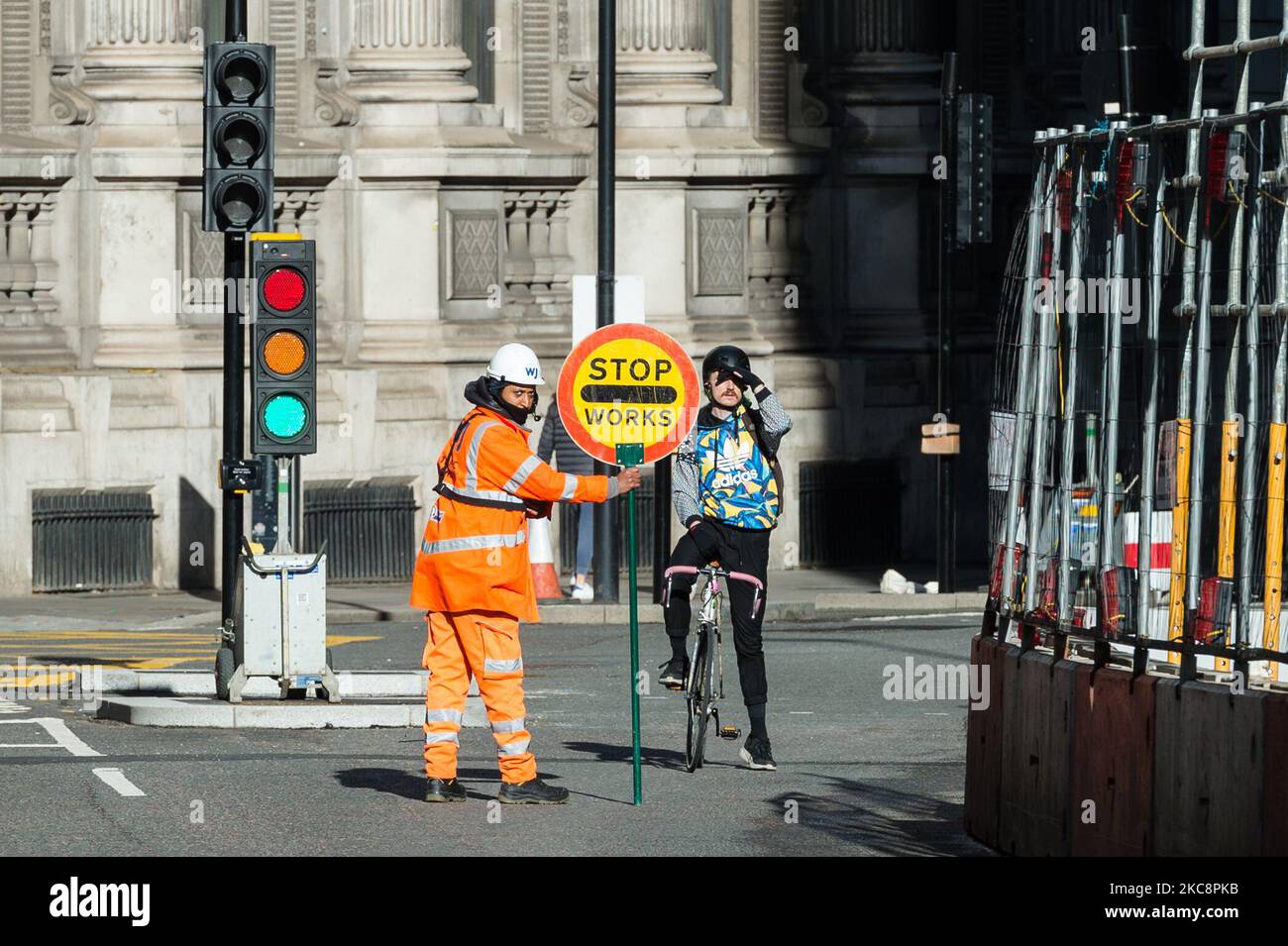 Il 05 febbraio 2021 a Londra, in Inghilterra, un operaio edile interrompe il traffico nella City of London, mentre l'Inghilterra rimane al di sotto del terzo blocco per ridurre i tassi di infezione da Covid-19. Il primo ministro Boris Johnson dovrebbe presentare i dettagli della tabella di marcia per le restrizioni al coronavirus il 22 febbraio, poiché il programma di vaccinazione è sulla buona strada per fornire la prima dose alle persone appartenenti a quattro gruppi prioritari entro la metà di febbraio e i tassi di infezione continuano a diminuire. (Foto di Wiktor Szymanowicz/NurPhoto) Foto Stock