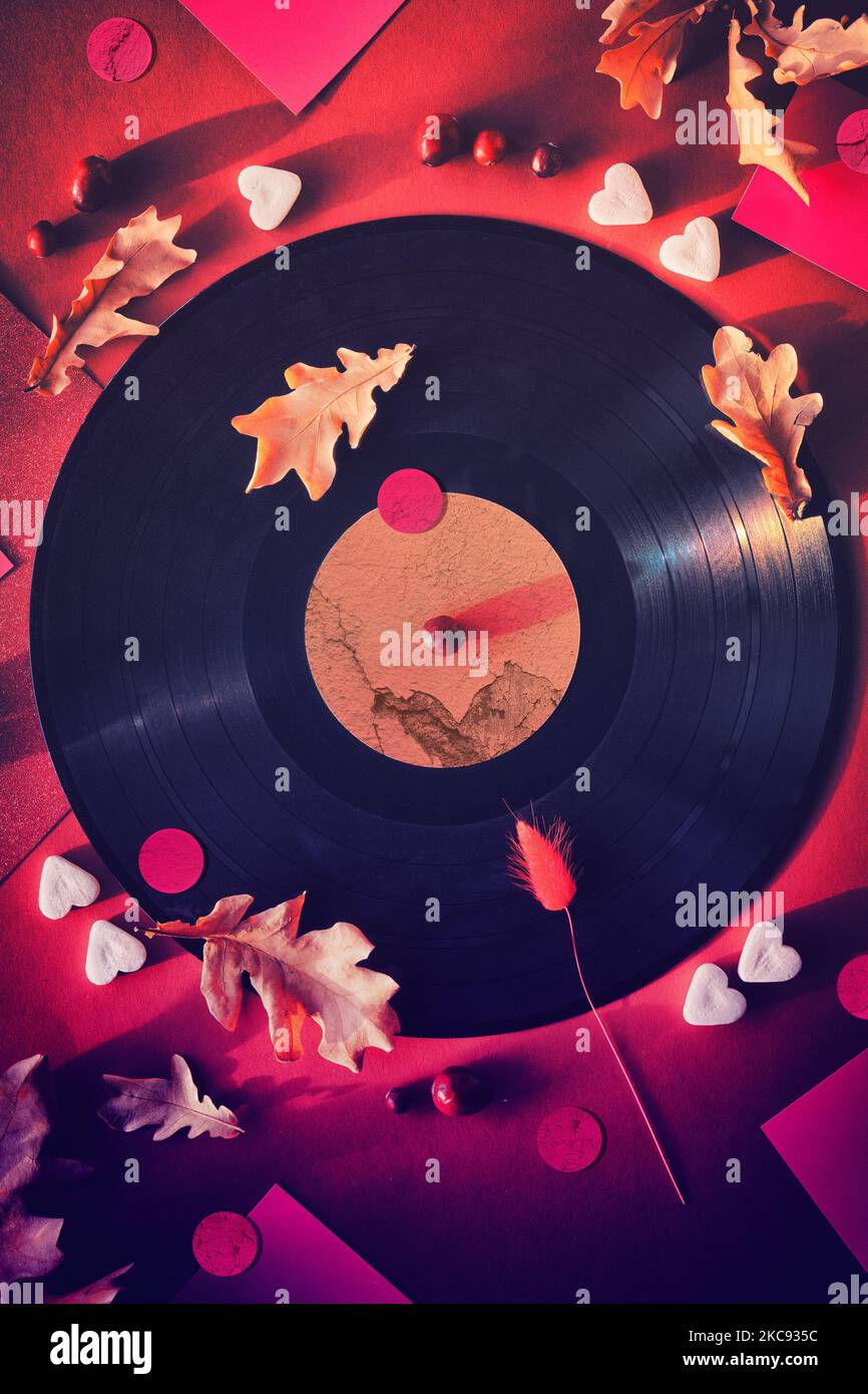 Il vinile vintage registra in maniche di carta su sfondo nero e maniche di carta. Foglie di rovere giallo su sfondo rosso con decorazioni autunnali. Zucchero Foto Stock