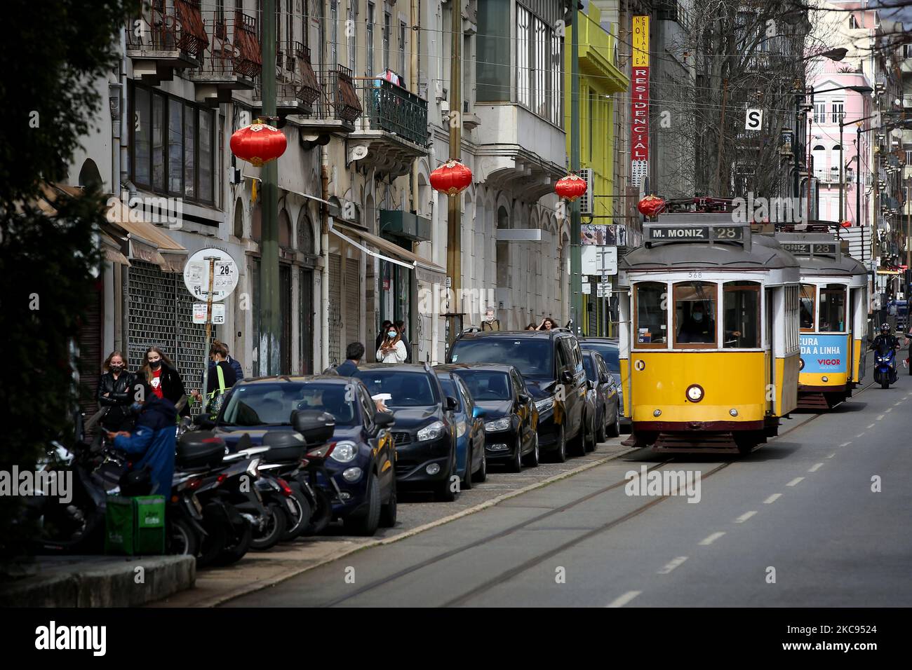 I tram passano dalle lanterne rosse che sono state messe in piedi per il Capodanno cinese che segna l'anno dell'Ox in Almirante Reis Avenue a Lisbona, Portogallo il 12 febbraio 2021. Quest'anno, con le restrizioni imposte dallo stato di emergenza in Portogallo a causa della pandemia COVID-19, la trasmissione online sostituisce le celebrazioni del Capodanno cinese, come la tradizionale sfilata con draghi, serpenti e acrobati, che attrae centinaia di persone ogni anno nel viale Almirante Reis, tuttavia, le tradizionali lanterne rosse adornano il viale, per segnare l'evento. (Foto di Pedro FiÃºza/NurPhoto) Foto Stock