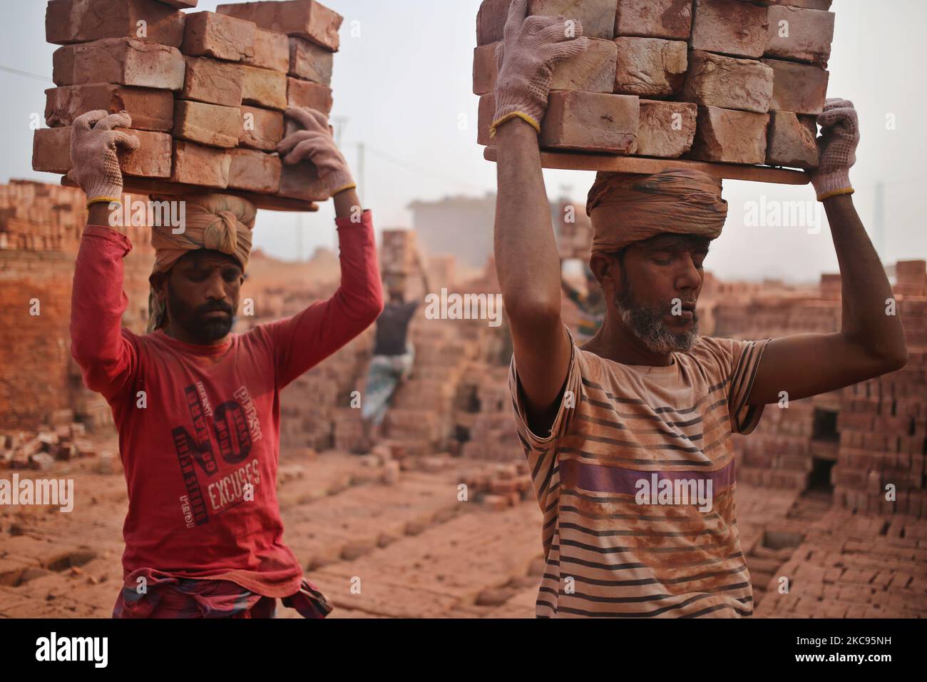 Lavoratori migranti stagionali durante il lavoro in un campo di mattoni a Dhaka, Bangladesh Sabato, 13 febbraio 2021. (Foto di Syed Mahamudur Rahman/NurPhoto) Foto Stock