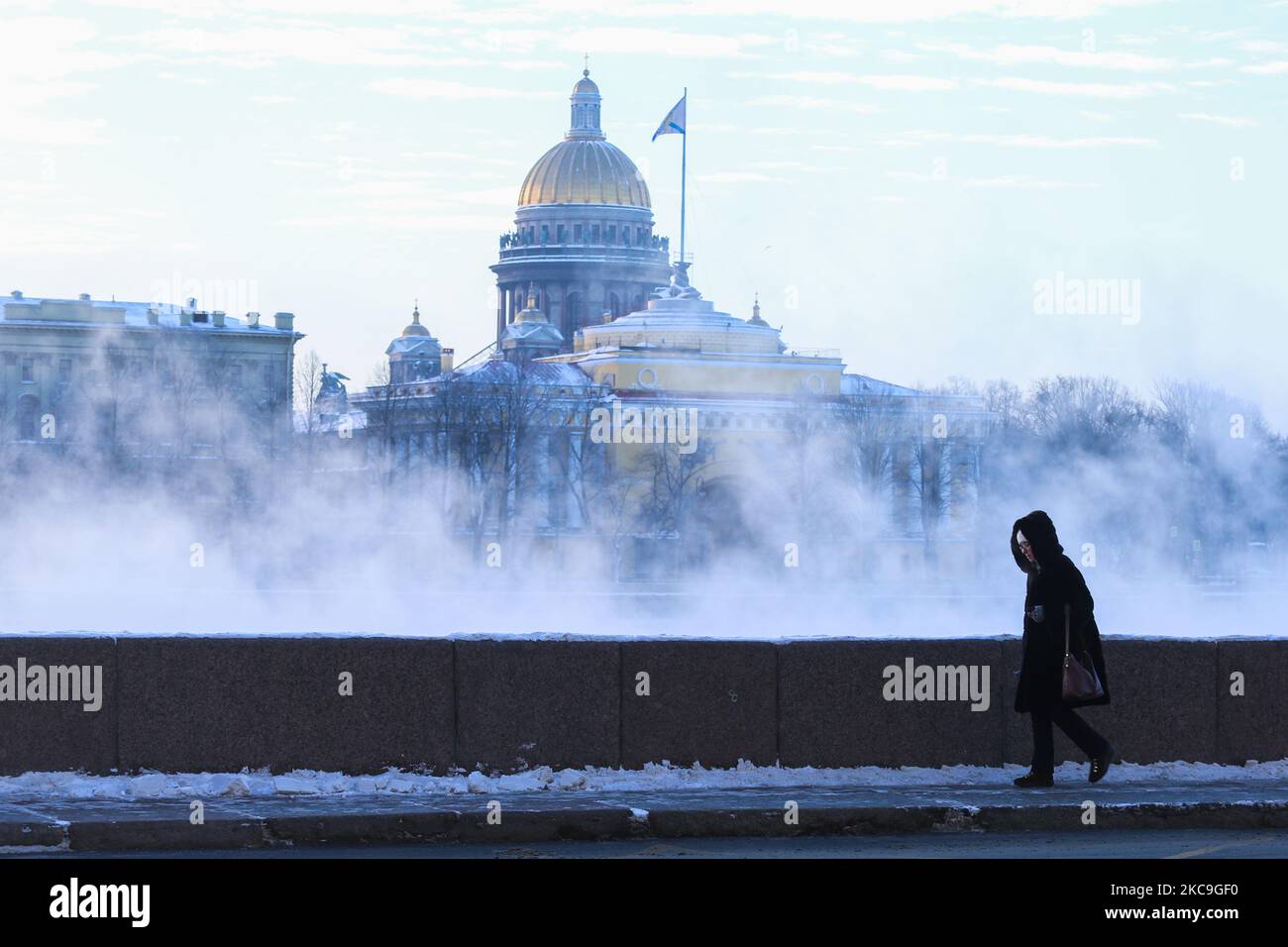 Una donna passa davanti alla nebbia sul fiume Neva congelato a San Pietroburgo. La temperatura dell'aria è scesa a -27 gradi. (Foto di Valya Egorshin/NurPhoto) Foto Stock