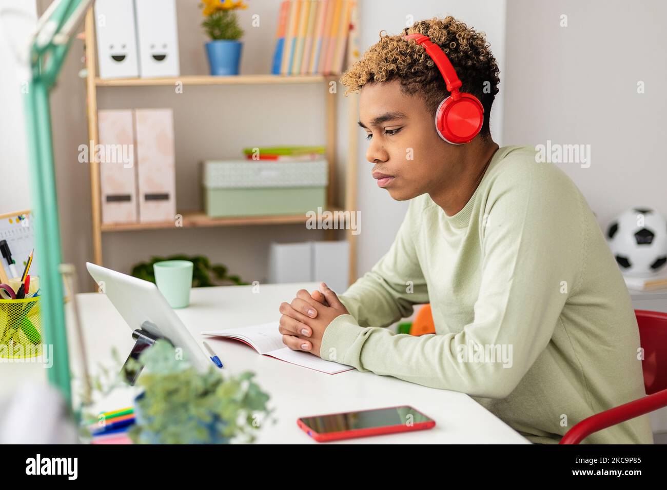 Concentrato giovane ispanico latino uomo imparare la lingua guardando corso online Foto Stock