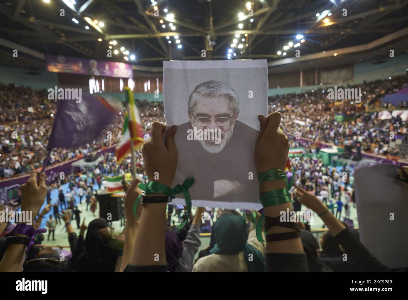 Un sostenitore del presidente riformista e del candidato alle elezioni presidenziali del 2017, Hassan Rouhani, tiene in mano un ritratto del leader iraniano dell'opposizione nei 2009 inarrestati post-elettorali, Mir-Hossein Mousavi mentre frequenta il complesso sportivo Azadi (libertà) da 12000 sit durante un rally di campagna a Teheran occidentale, il 13 maggio 2017. Rouhani rieletto presidente dell'Iran. (Foto di Morteza Nikoubazl/NurPhoto) Foto Stock