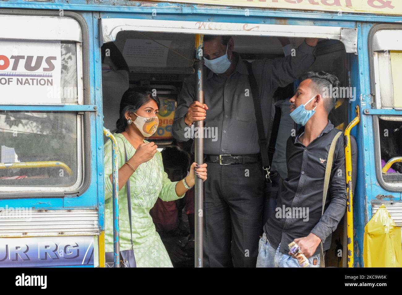 Un conduttore di autobus visto indossare una maschera in modo improprio interagisce con un passeggero in un autobus privato a Kolkata. (Foto di Debarchan Chatterjee/NurPhoto) Foto Stock