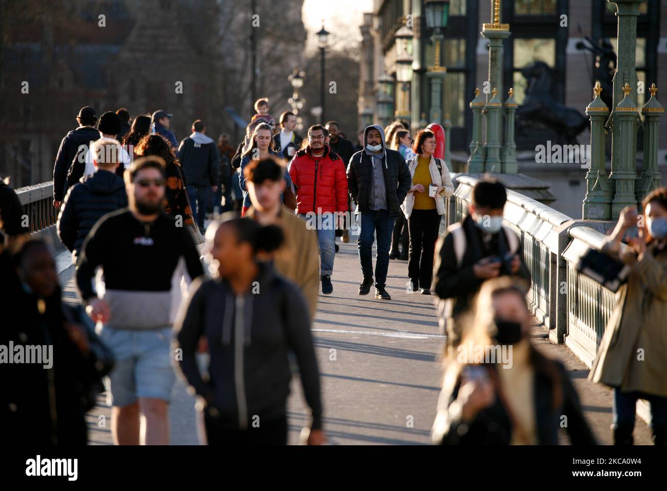 La gente attraversa Westminster Bridge in un clima mite primaverile a Londra, Inghilterra, il 26 febbraio 2021. (Foto di David Cliff/NurPhoto) Foto Stock