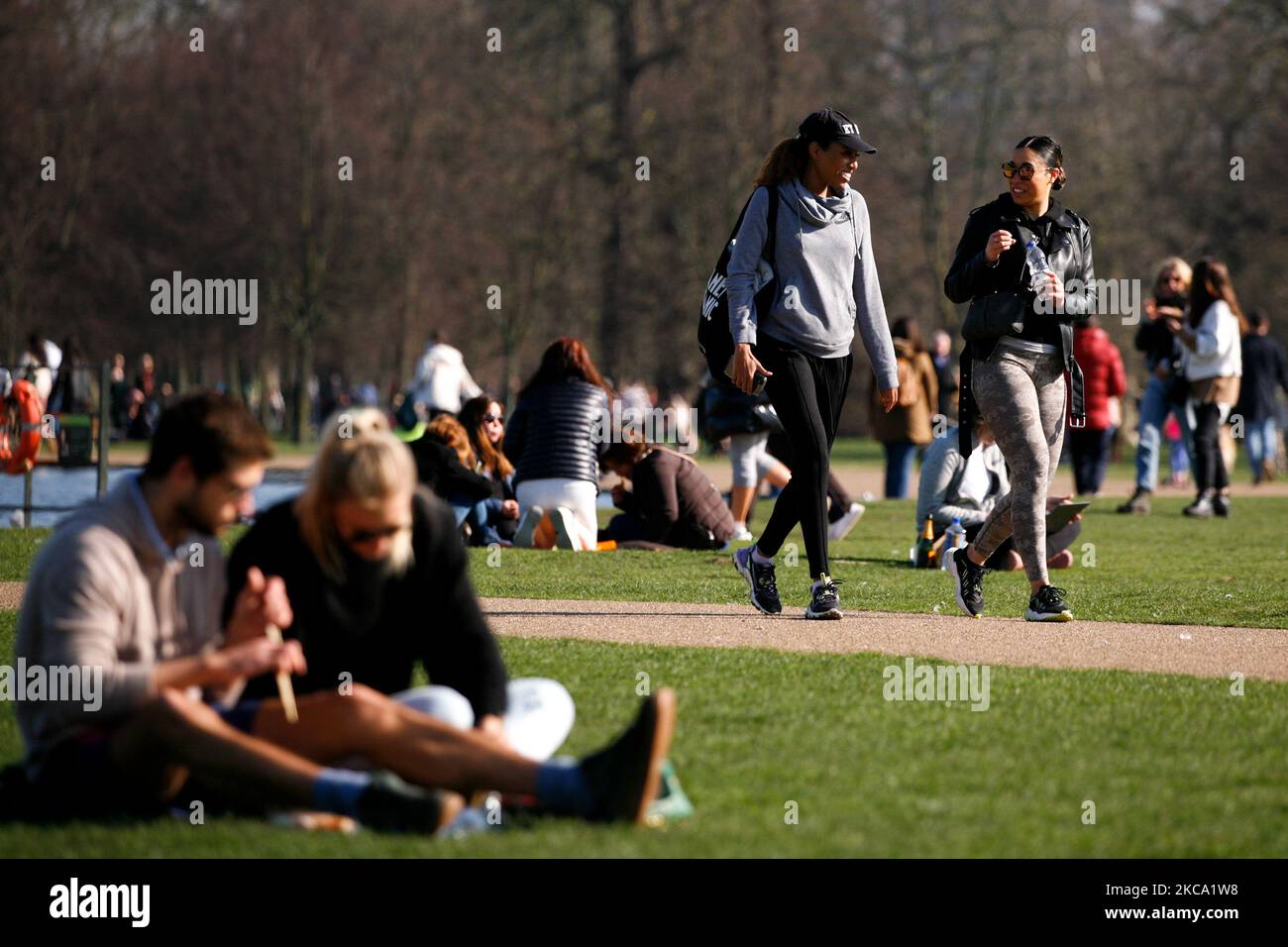 La gente gode del sole primaverile accanto al Round Pond a Kensington Gardens a Londra, in Inghilterra, il 27 febbraio 2021. (Foto di David Cliff/NurPhoto) Foto Stock