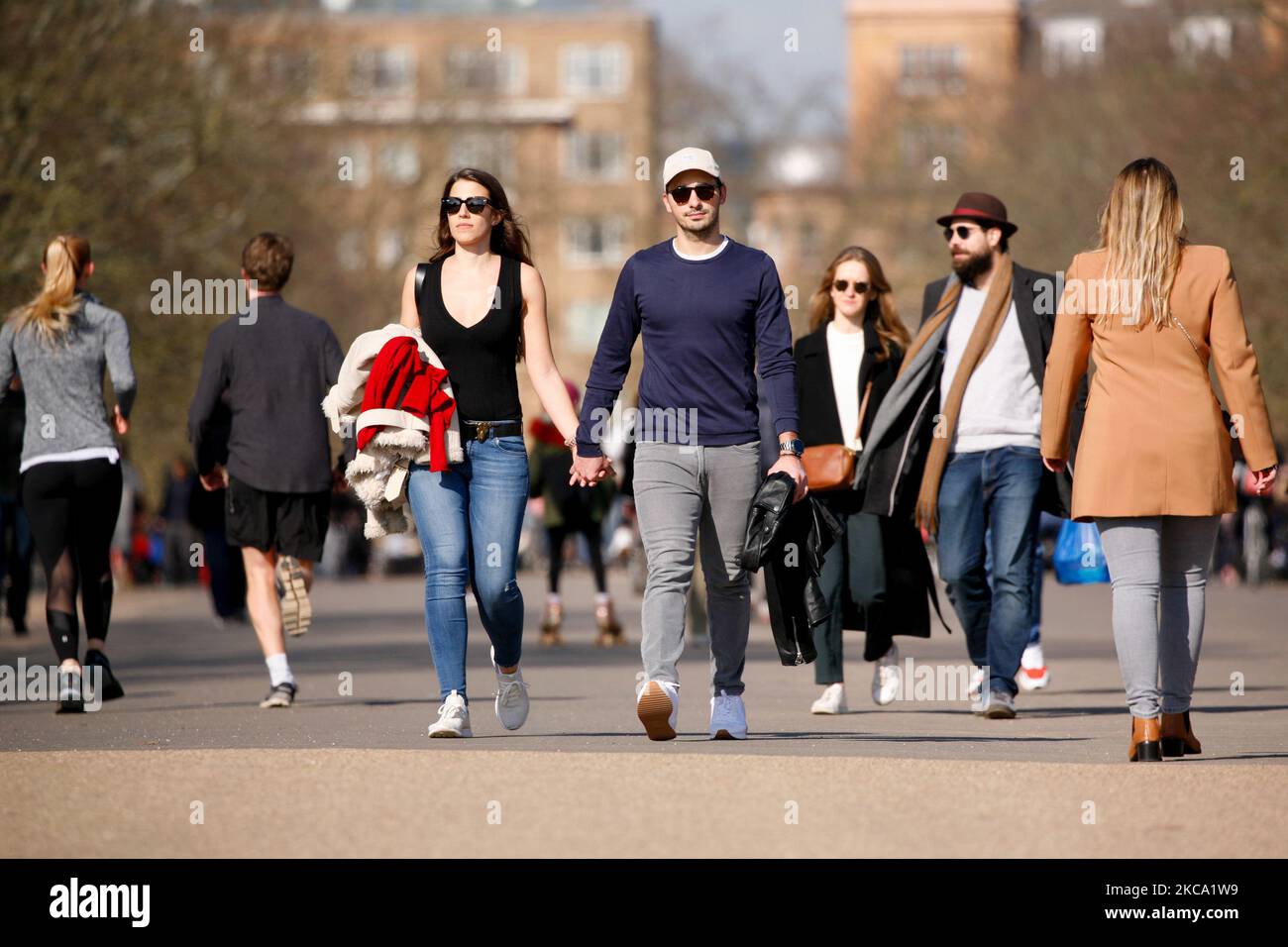 Una coppia cammina attraverso il sole primaverile nei Kensington Gardens a Londra, Inghilterra, il 27 febbraio 2021. (Foto di David Cliff/NurPhoto) Foto Stock
