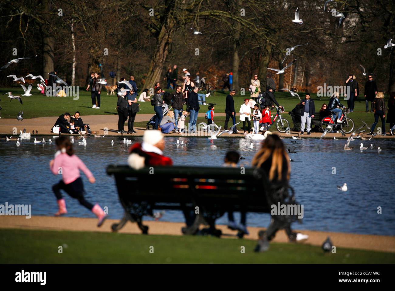 La gente gode del sole primaverile accanto al Round Pond a Kensington Gardens a Londra, in Inghilterra, il 27 febbraio 2021. (Foto di David Cliff/NurPhoto) Foto Stock