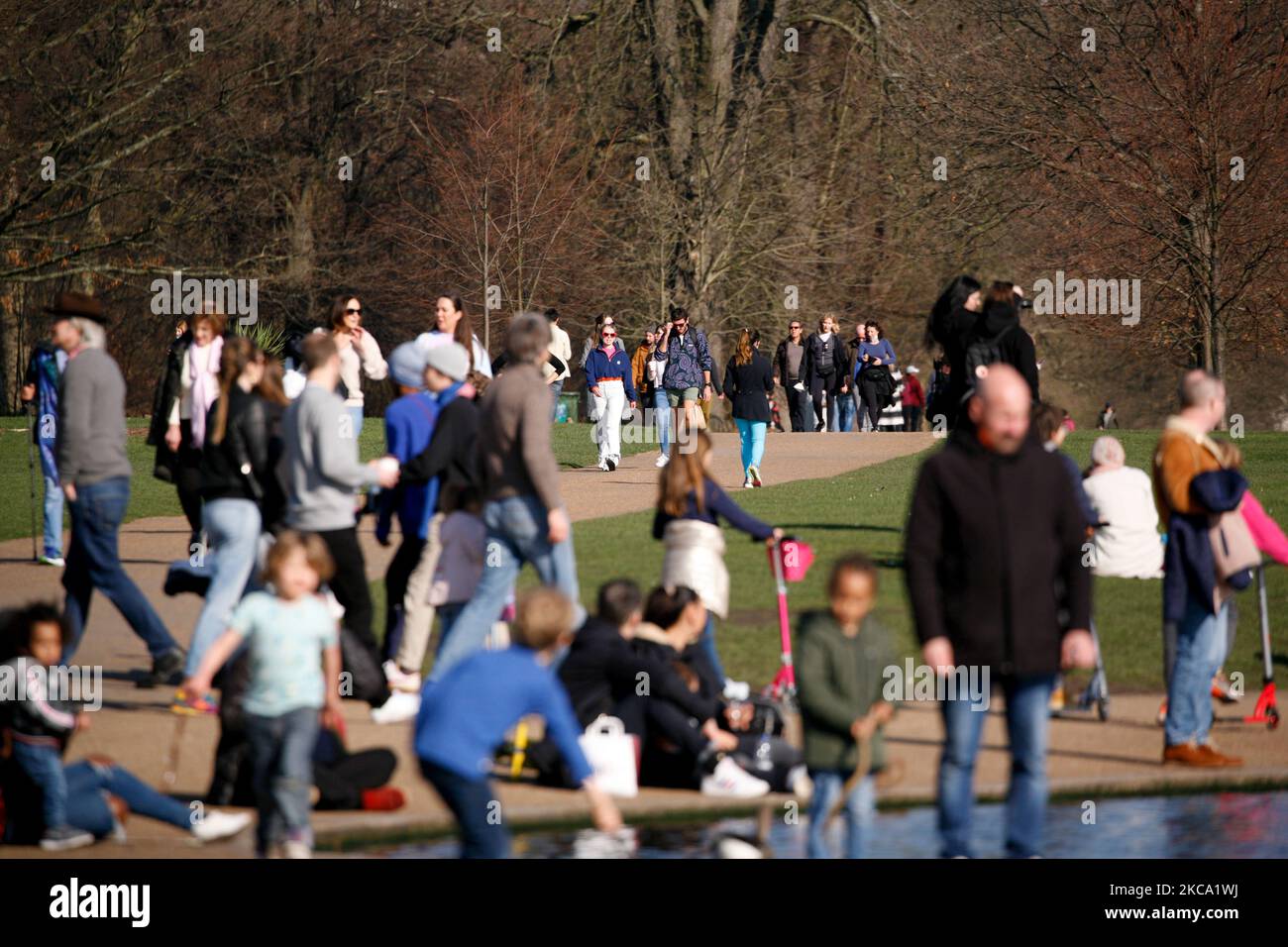 La gente gode del sole primaverile accanto al Round Pond a Kensington Gardens a Londra, in Inghilterra, il 27 febbraio 2021. (Foto di David Cliff/NurPhoto) Foto Stock