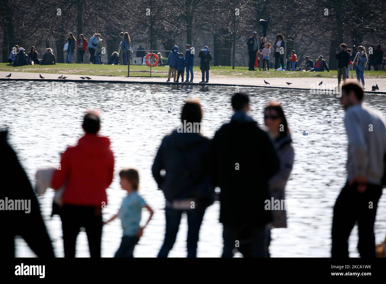 La gente gode del sole primaverile accanto al Round Pond a Kensington Gardens a Londra, in Inghilterra, il 27 febbraio 2021. (Foto di David Cliff/NurPhoto) Foto Stock