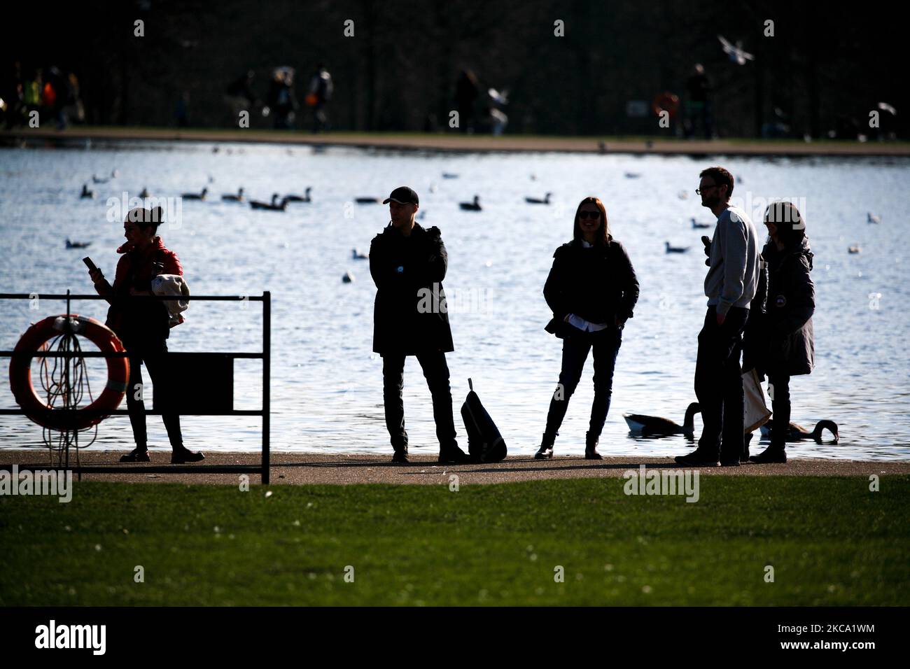 La gente gode del sole primaverile accanto al Round Pond a Kensington Gardens a Londra, in Inghilterra, il 27 febbraio 2021. (Foto di David Cliff/NurPhoto) Foto Stock