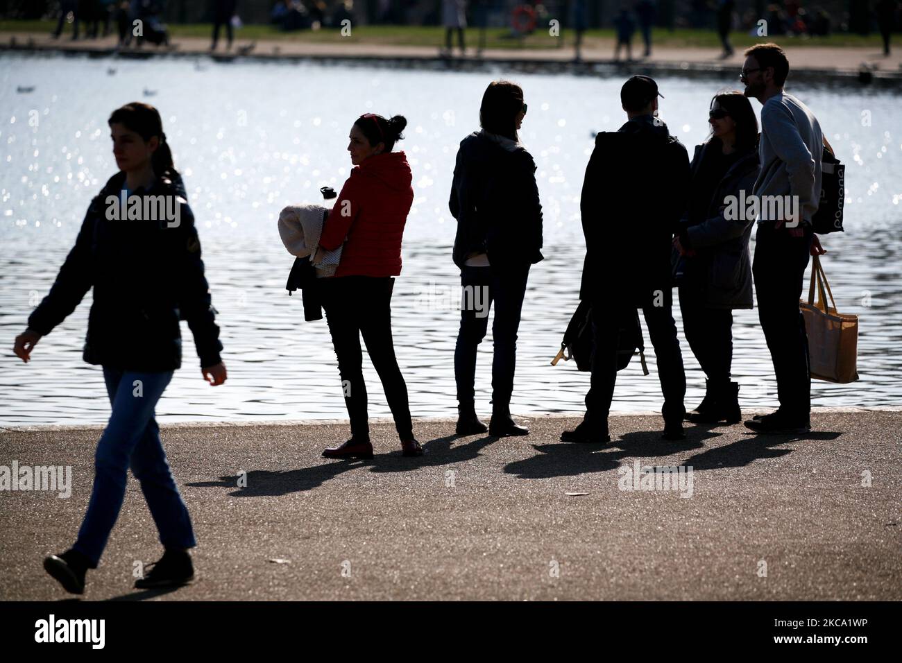 La gente gode del sole primaverile accanto al Round Pond a Kensington Gardens a Londra, in Inghilterra, il 27 febbraio 2021. (Foto di David Cliff/NurPhoto) Foto Stock