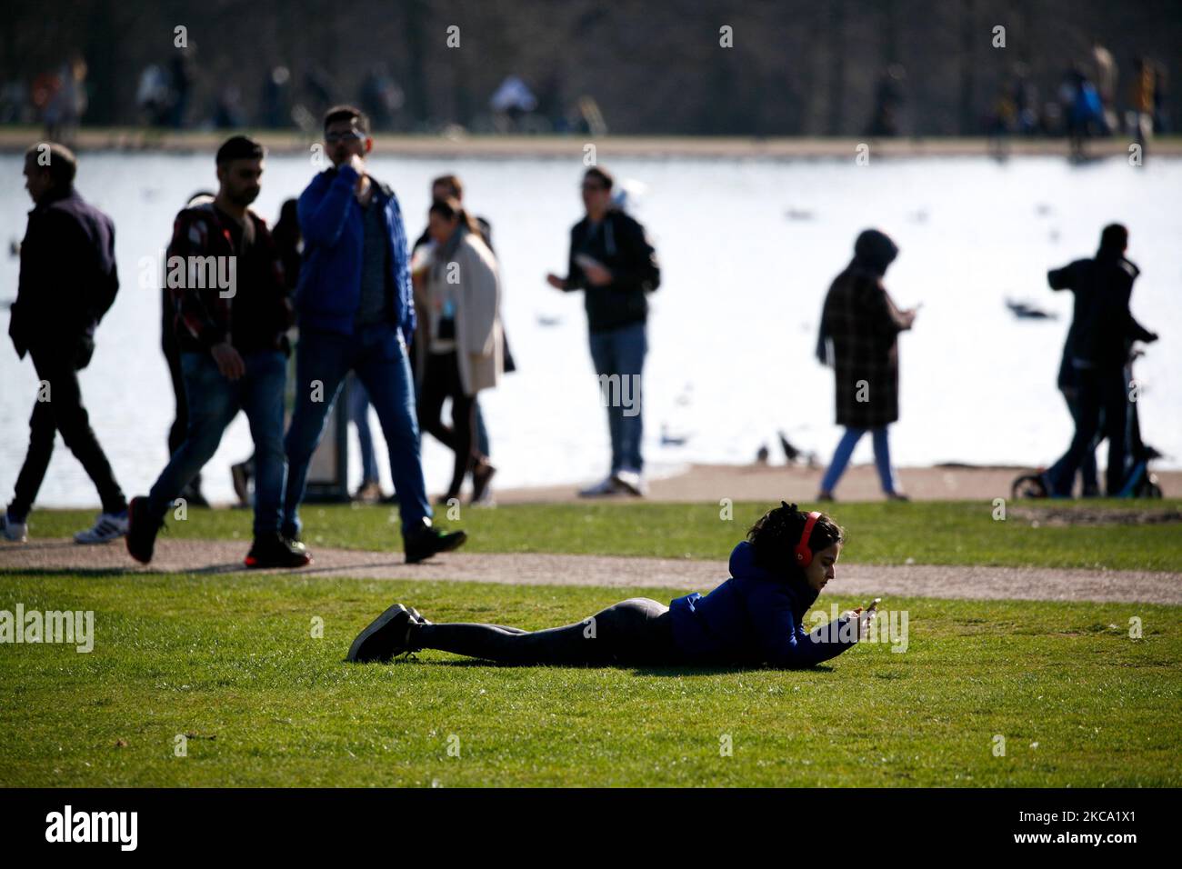 La gente gode del sole primaverile accanto al Round Pond a Kensington Gardens a Londra, in Inghilterra, il 27 febbraio 2021. (Foto di David Cliff/NurPhoto) Foto Stock
