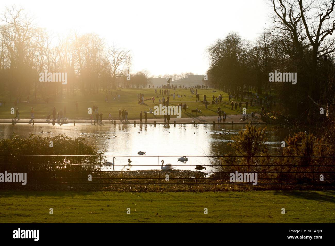La gente cammina attraverso il sole primaverile nel tardo pomeriggio nei Kensington Gardens a Londra, Inghilterra, il 27 febbraio 2021. (Foto di David Cliff/NurPhoto) Foto Stock