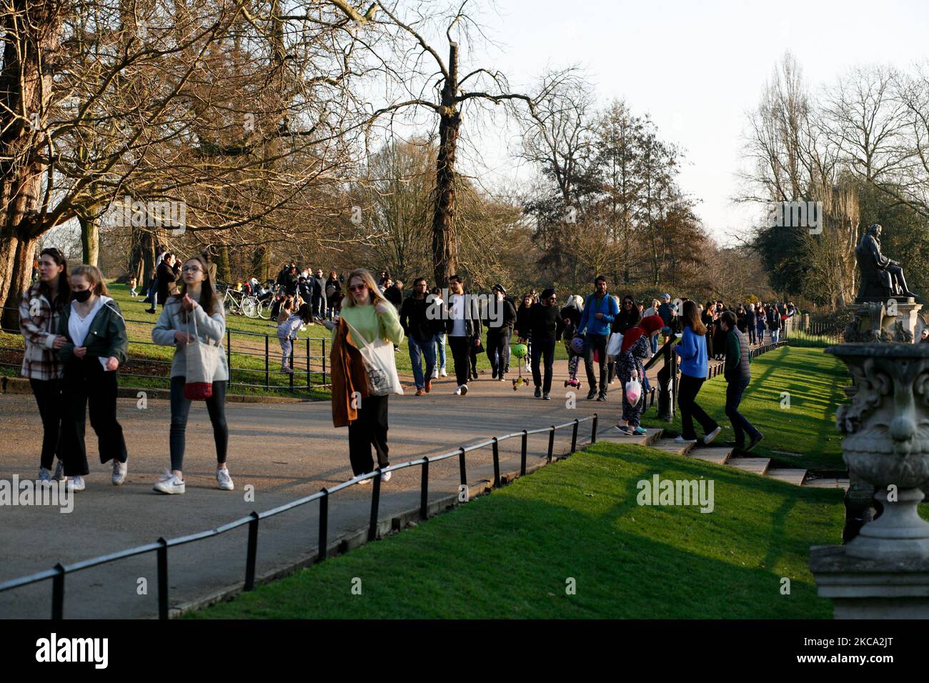 La gente cammina attraverso il sole primaverile nel tardo pomeriggio nei Kensington Gardens a Londra, Inghilterra, il 27 febbraio 2021. (Foto di David Cliff/NurPhoto) Foto Stock