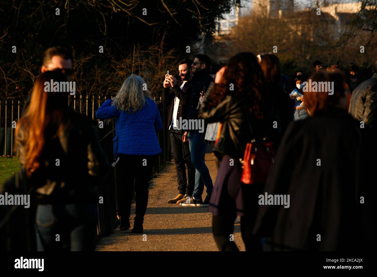 La gente cammina attraverso il sole primaverile nel tardo pomeriggio nei Kensington Gardens a Londra, Inghilterra, il 27 febbraio 2021. (Foto di David Cliff/NurPhoto) Foto Stock