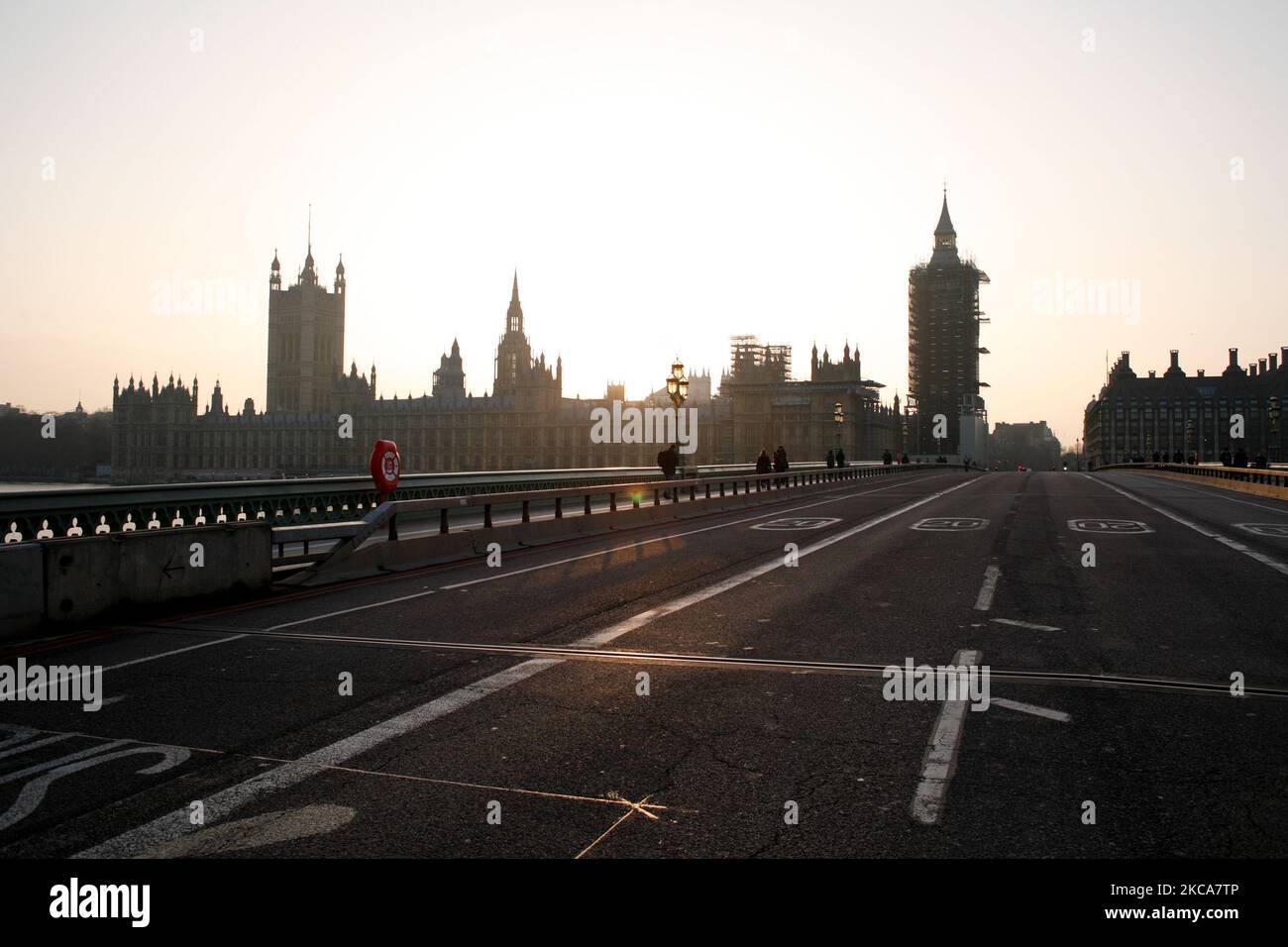 Il Westminster Bridge è momentaneamente vuoto di traffico mentre il sole tramonta dietro le Houses of Parliament a Londra, in Inghilterra, il 2 marzo 2021. (Foto di David Cliff/NurPhoto) Foto Stock