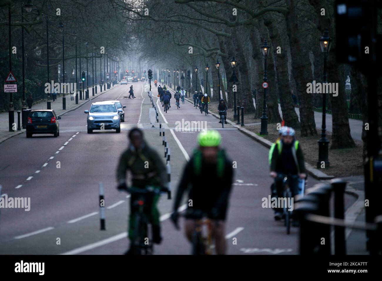 Ciclisti e traffico passano lungo Birdcage Walk al tramonto a Londra, Inghilterra, il 2 marzo 2021. (Foto di David Cliff/NurPhoto) Foto Stock