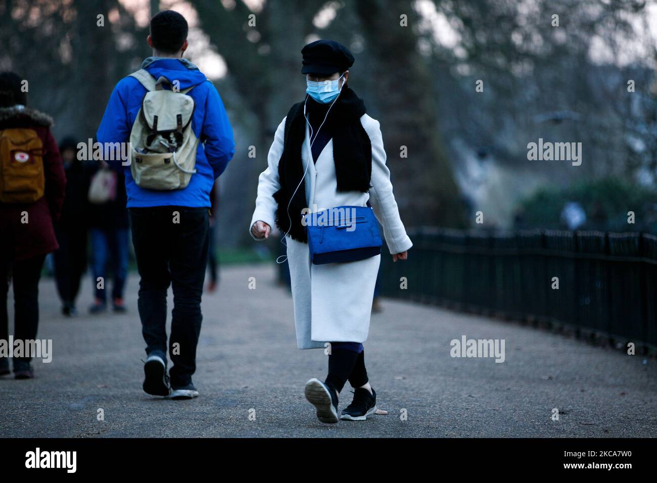 Una donna che indossa una maschera facciale cammina attraverso il St James's Park al tramonto a Londra, Inghilterra, il 2 marzo 2021. (Foto di David Cliff/NurPhoto) Foto Stock