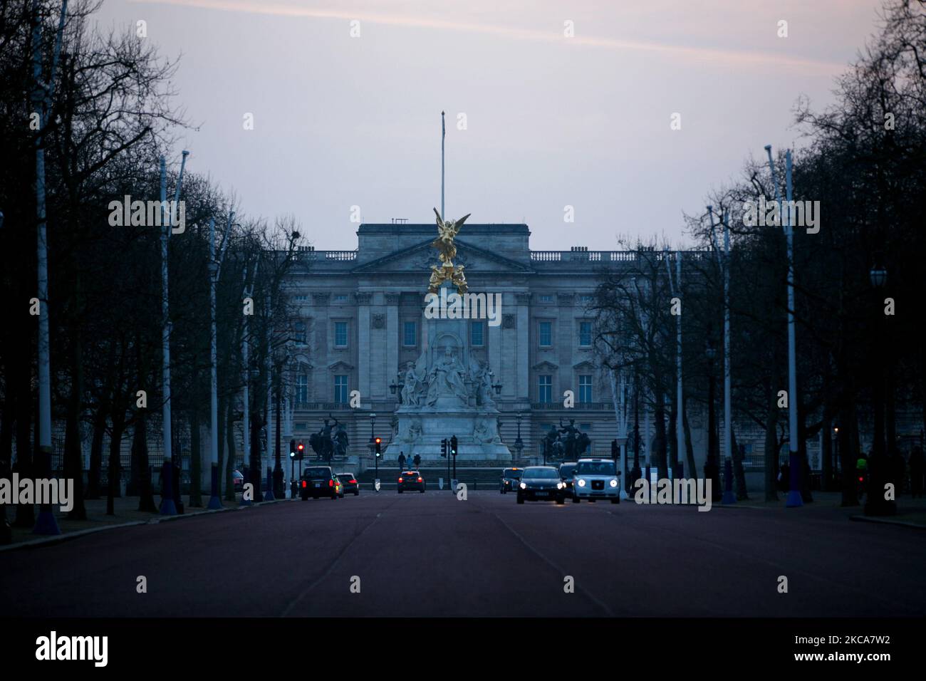 Il traffico viaggia lungo il Mall mentre il sole tramonta dietro Buckingham Palace a Londra, in Inghilterra, il 2 marzo 2021. (Foto di David Cliff/NurPhoto) Foto Stock