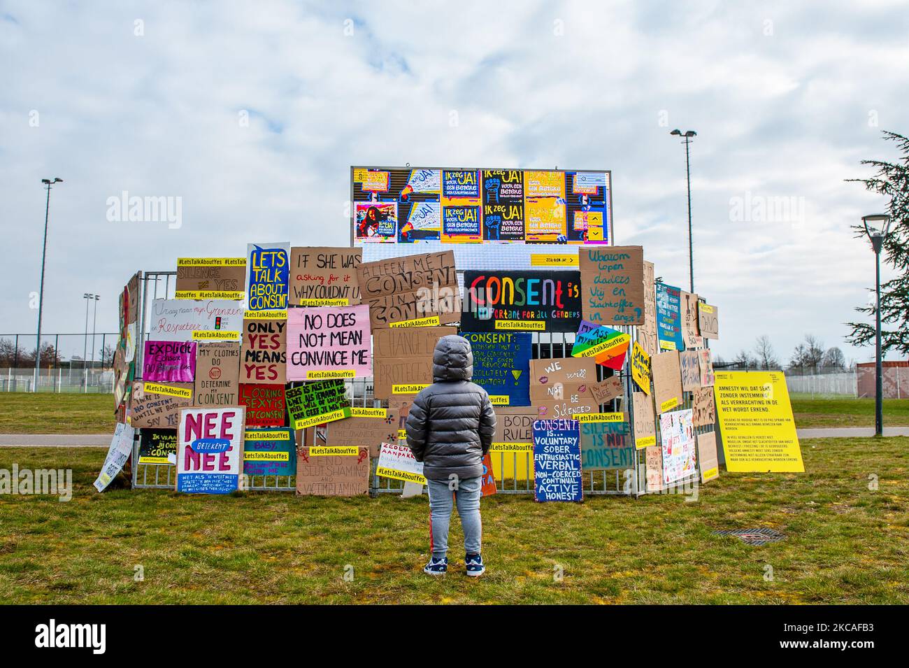Un ragazzino sta guardando uno stand di Amnesty International pieno di cartelloni pro-femministi, Una donna sta alzando la mano mentre tiene un cartellone, durante il 2021 marzo delle donne celebrato ad Amsterdam il 7th marzo 2021. (Foto di Romy Arroyo Fernandez/NurPhoto) Foto Stock