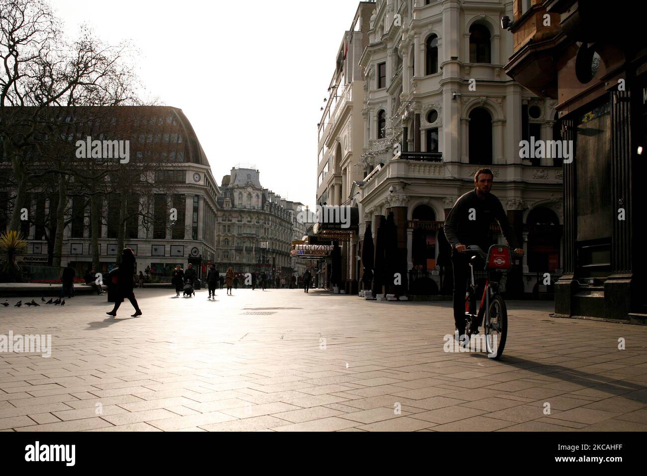 Un uomo guida una bicicletta a noleggio davanti a cinema chiusi, casinò e ristoranti in una vicina e deserta Leicester Square a Londra, Inghilterra, il 8 marzo 2021. Oggi ha segnato la prima fase dell’allentamento del blocco del coronavirus in tutta l’Inghilterra, con la riapertura delle scuole e l’allentamento di alcuni limiti sui contatti sociali. I negozi non essenziali, i bar, i ristoranti e le altre aziende di ospitalità rimangono comunque chiusi e riapriranno solo il mese prossimo secondo gli orari attuali. (Foto di David Cliff/NurPhoto) Foto Stock