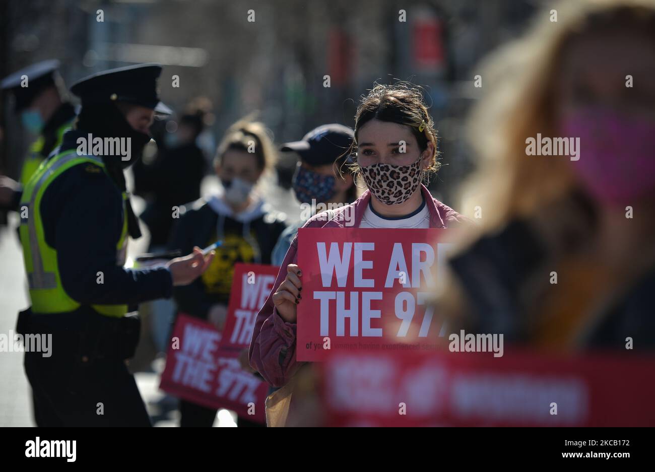 Gardai (polizia irlandese) verifica dell'identità di un manifestante durante una protesta di solidarietà con le donne nel Regno Unito contro la violenza di genere su o'Connell Street a Dublino. La tragica uccisione di Sarah Everard, 33 anni, a Londra ha suscitato indignazione tra le donne in Gran Bretagna, Irlanda e in tutto il mondo. Gli attivisti chiedono ulteriori azioni per combattere la violenza contro le donne. Martedì 16 marzo 2021 a Dublino, Irlanda. (Foto di Artur Widak/NurPhoto) Foto Stock
